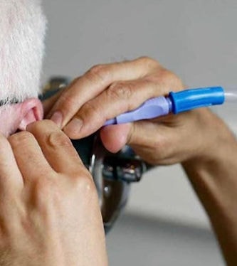 Clinician performing microsuction earwax removal